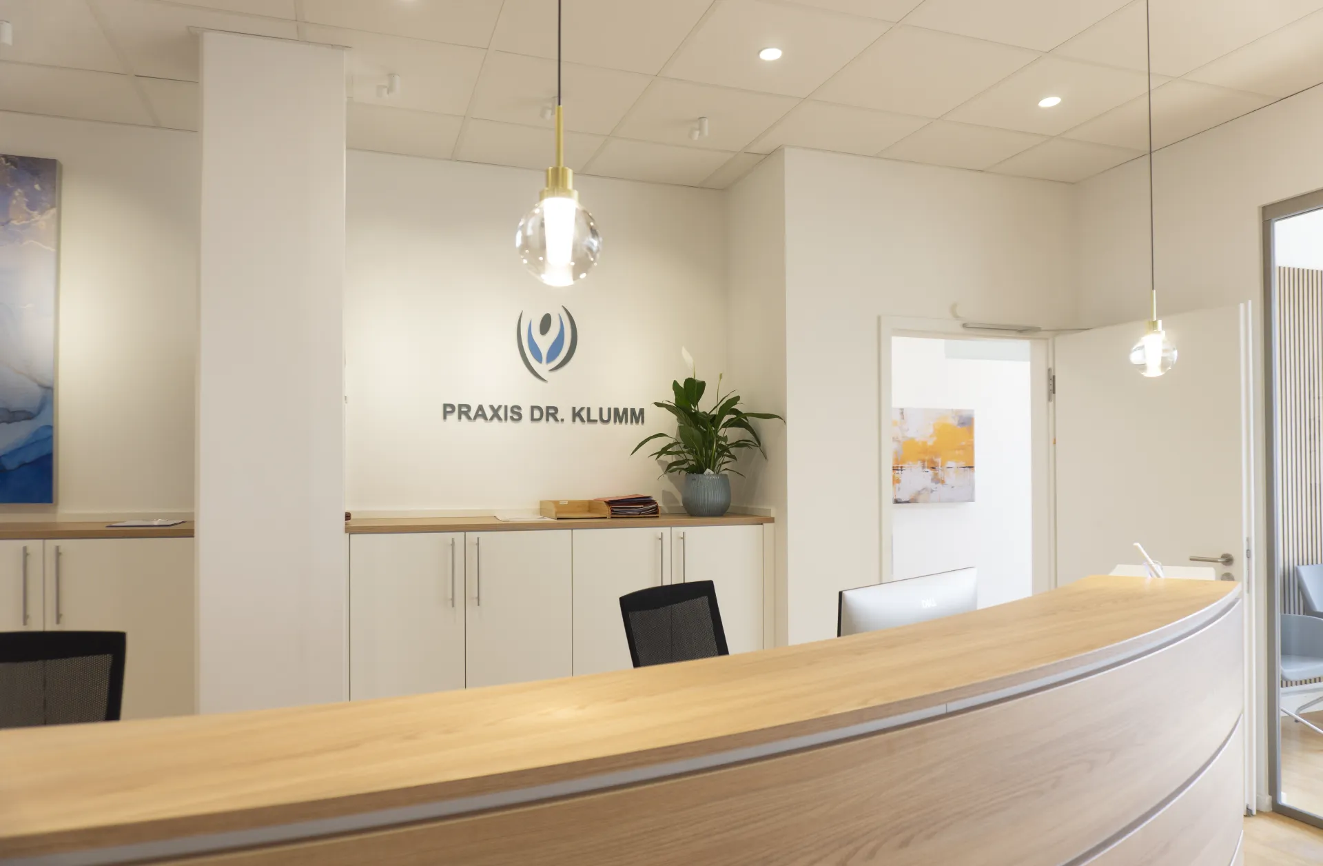 Spherical pendant luminaire Alaska and downlight Buddy at the counter of a reception area